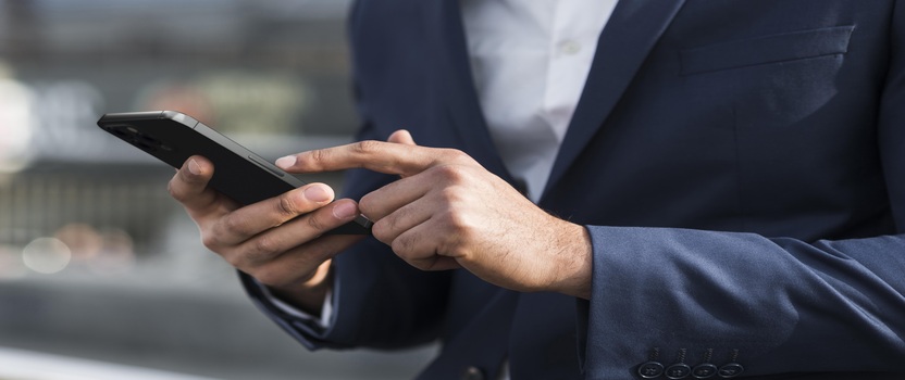 Homem usando smartphone em ambiente de trabalho