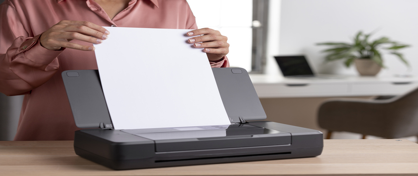 Pessoa colocando papel em impressora moderna