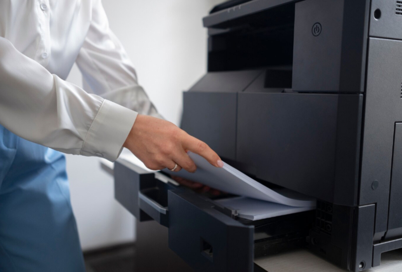 Pessoa colocando papel em impressora
