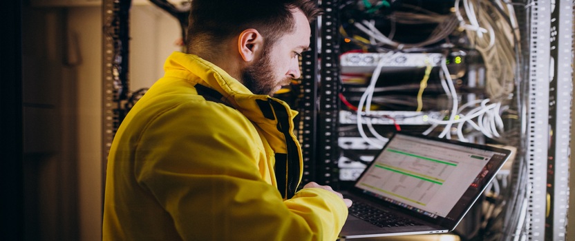Técnico trabalhando em servidor com laptop